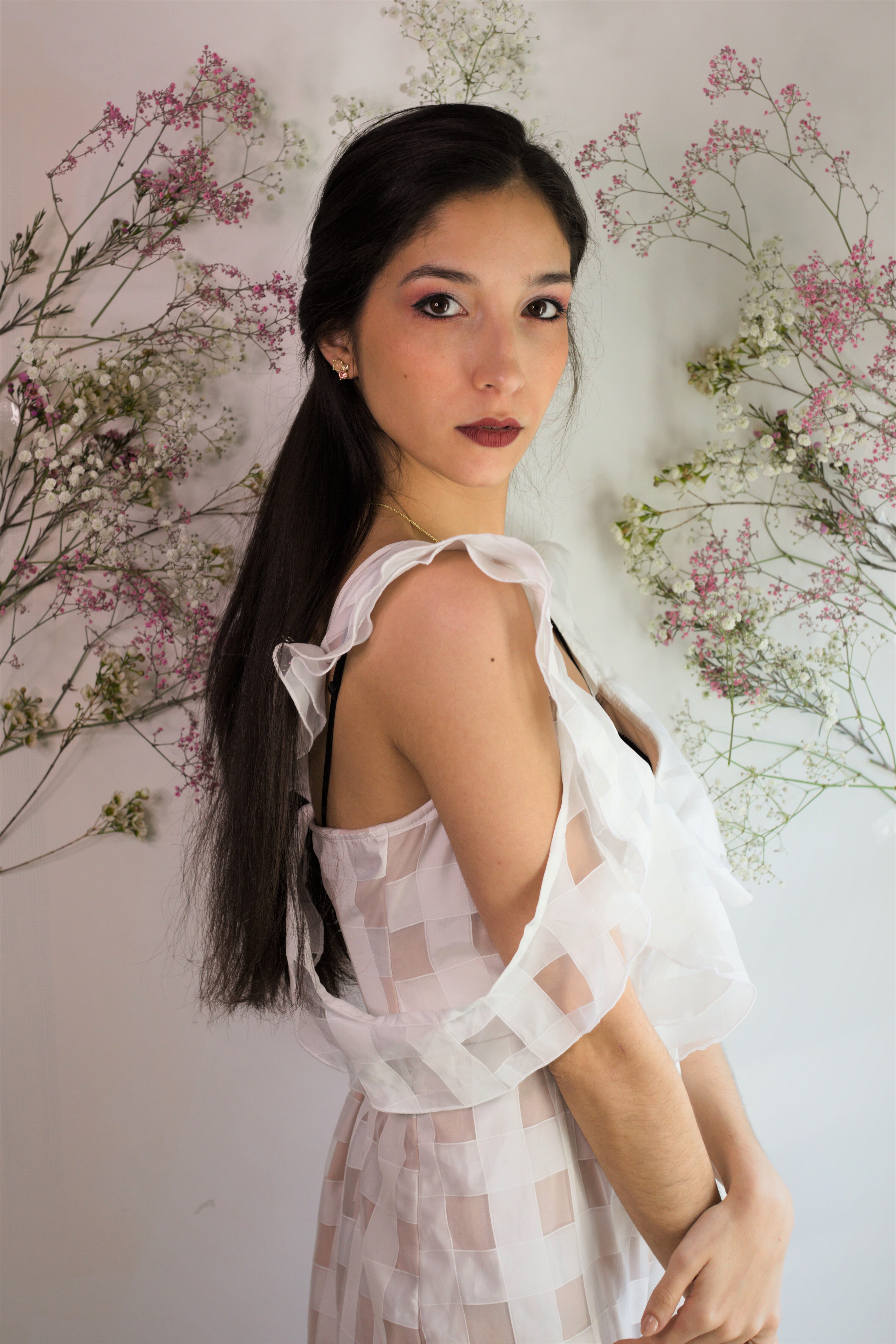 A girl wearing a white dress with a floral background set design