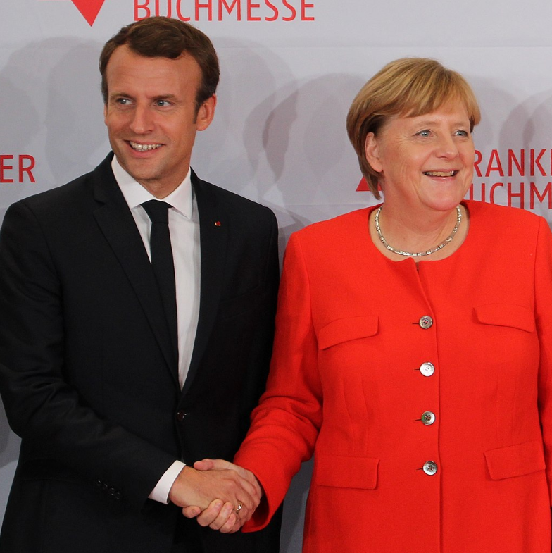 Angela Merkel and Emmanuel Macron shake hands, image credit: wikimedia commons