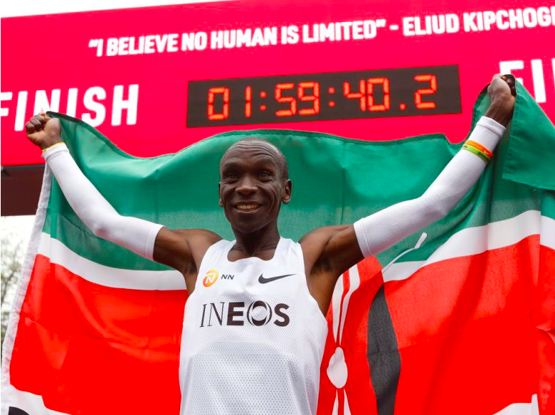 Marathon runner Eliud Kipchoge from Kenya celebrates under the clock Saturday after crossing the finish line of the INEOS 1:59 Challenge after 1:59:40 in Vienna, Austria/Image Credit:Associated Press
