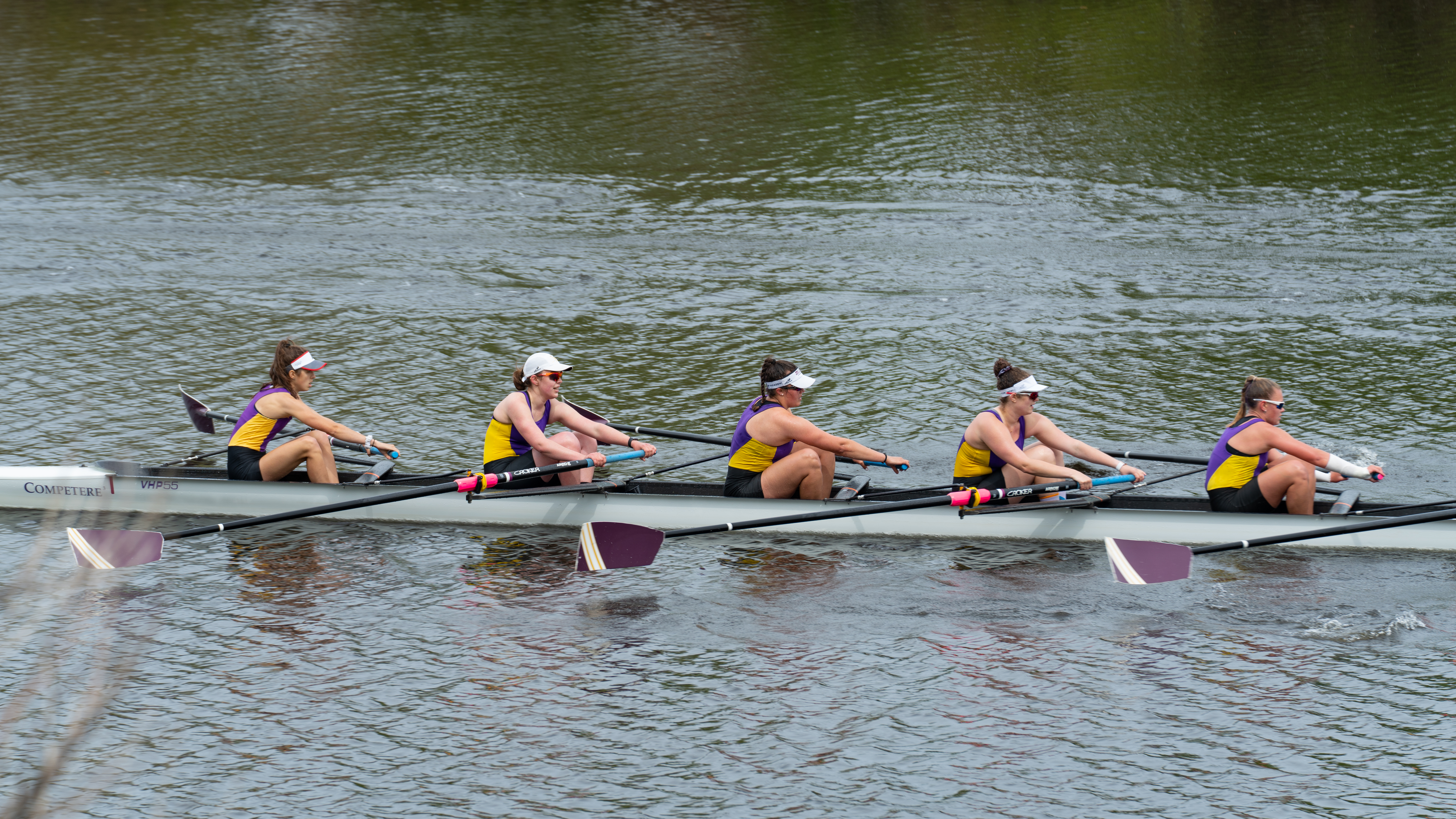 A competitive crew rowing on the water.
