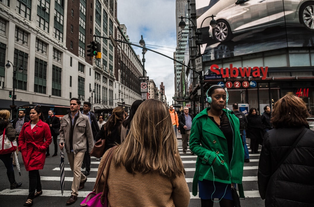 Woman Wearing Green Jacket in Pedestrian Lane During Daytime