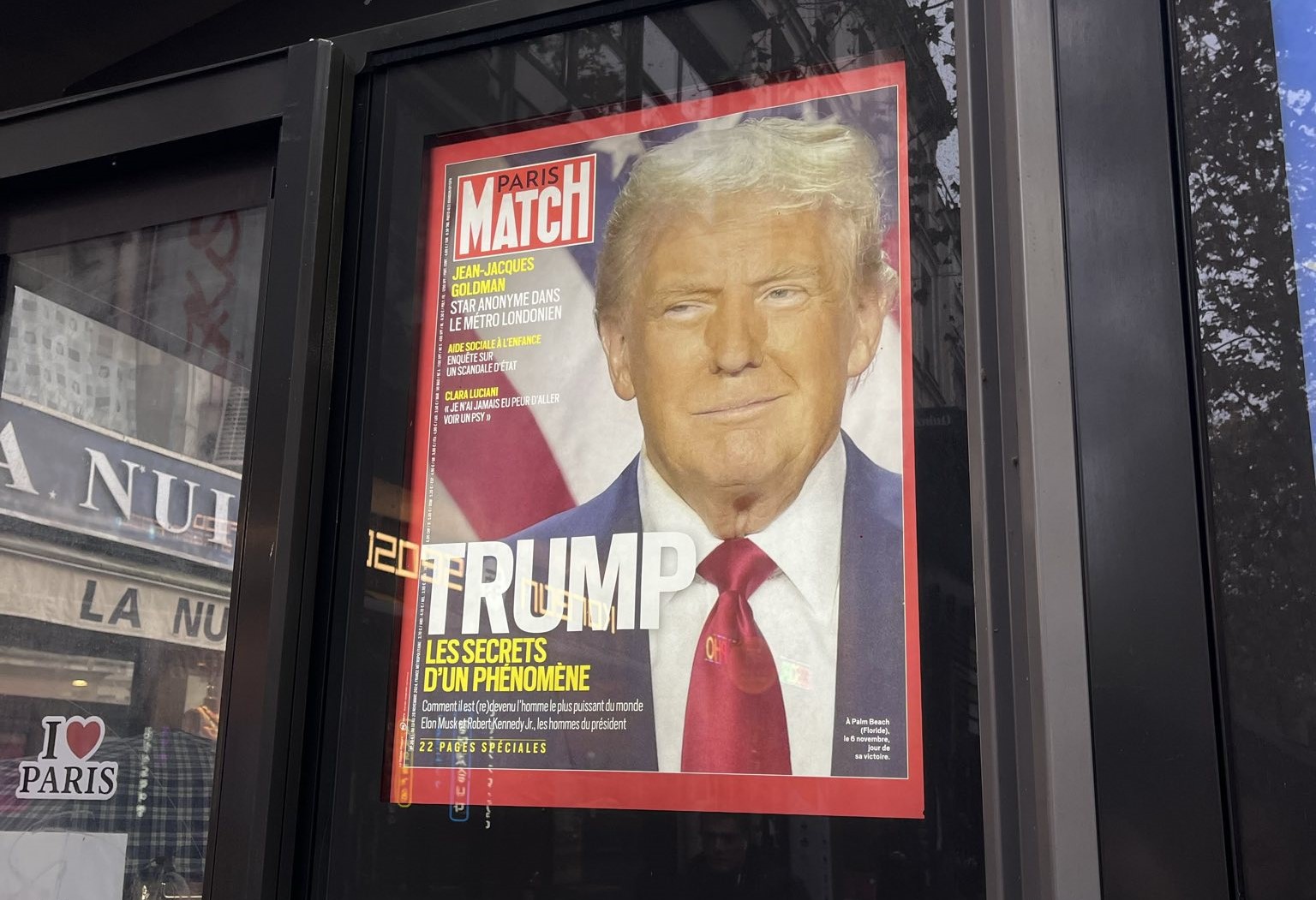 The side of a news stand shows Donald Trump's face on a poster cover of Paris Match