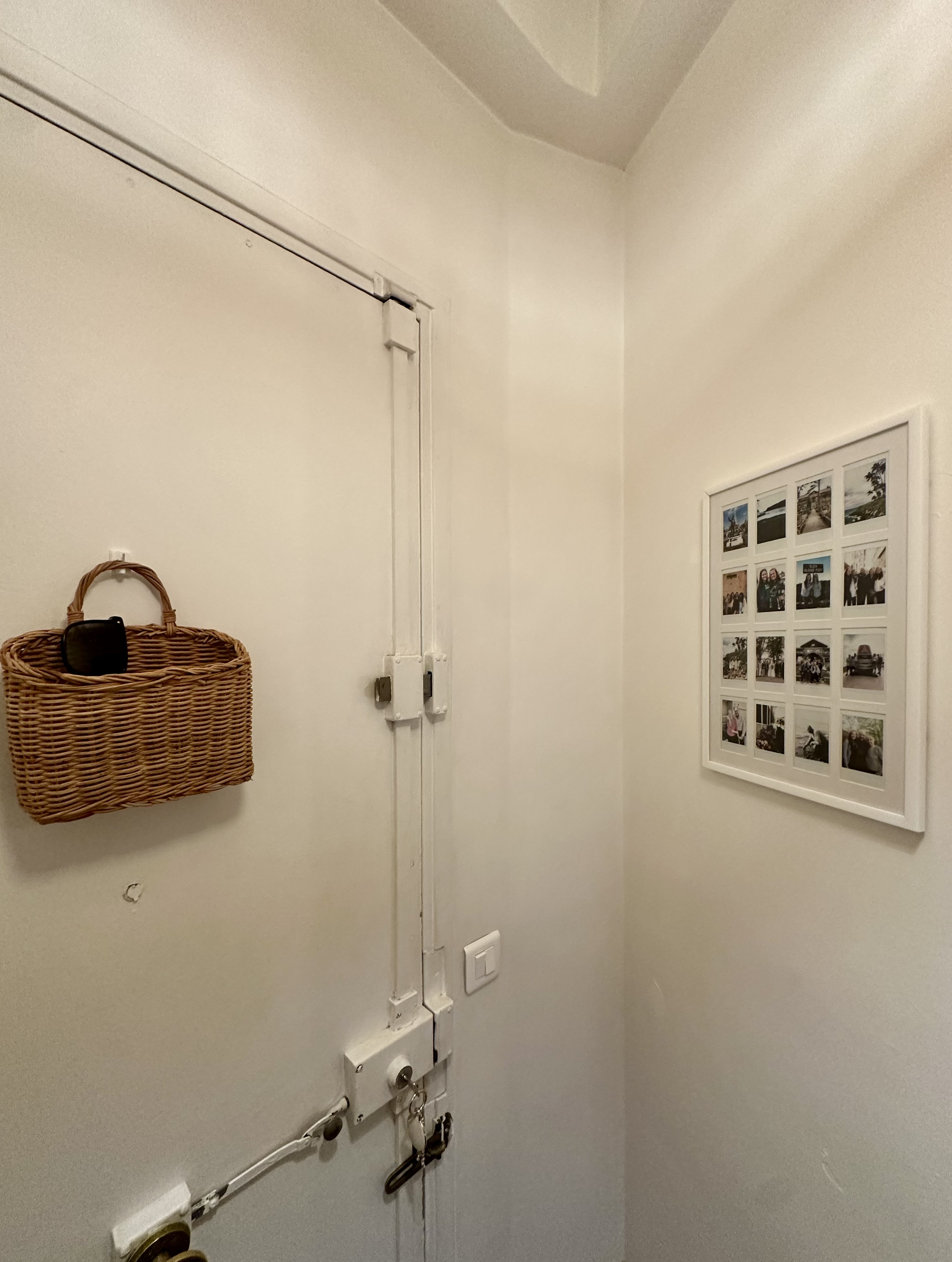 A polaroid frame filled with personal photos helps frame my entry way.