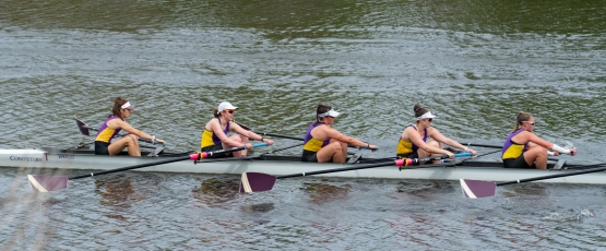 A competitive crew rowing on the water.