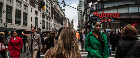 Woman Wearing Green Jacket in Pedestrian Lane During Daytime