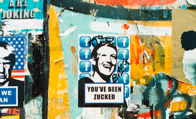 A poster with Mark Zuckerburg's face and the words "You've been Zucked" is glued on a wall covered in graffiti.