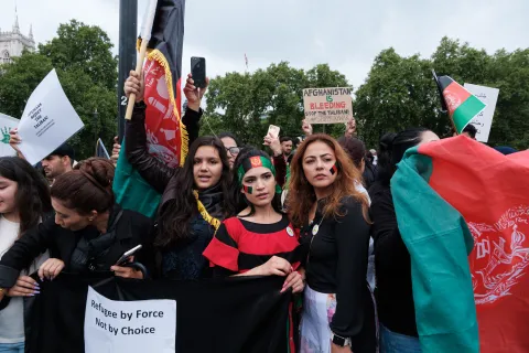 Afghan protesting against the Taliban. They are carrying the Afghan flag, and signs.